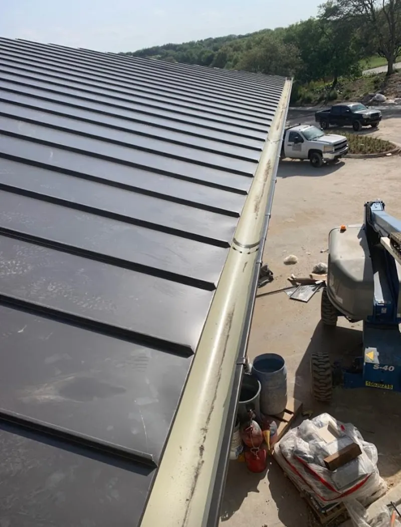 Standing seam panel and gutter detail on a metal roofing jobsite in North Springfield